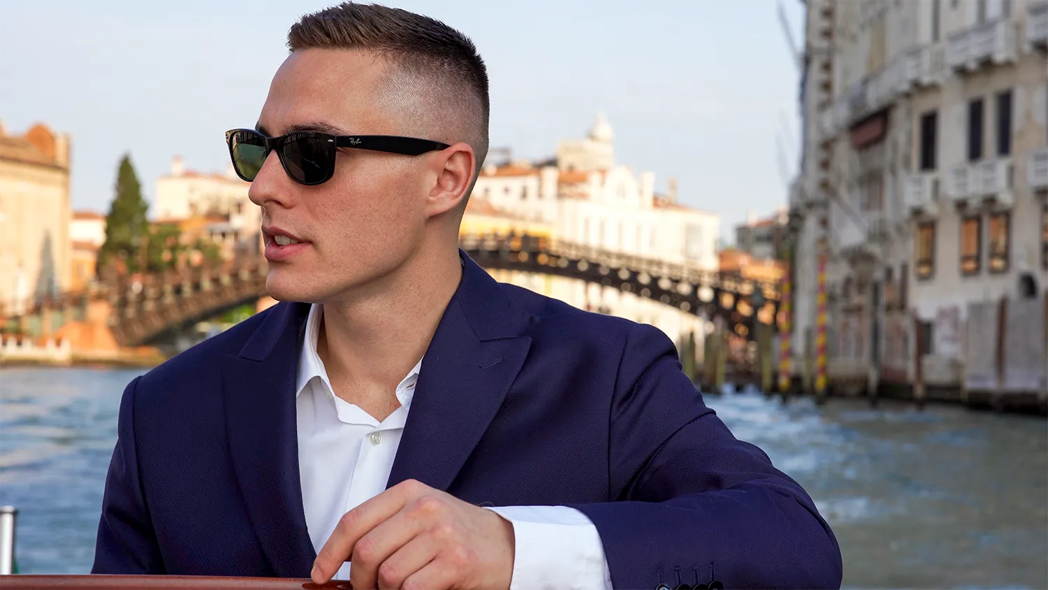 Portrait ofRelap Group Real Estate Founder, CEO & Broker - Tommaso Gregianin in a watertaxi in Venice wearing sunglasses